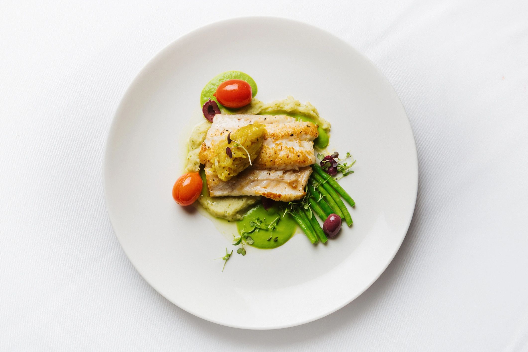 Grilled fish plated with vegetables
